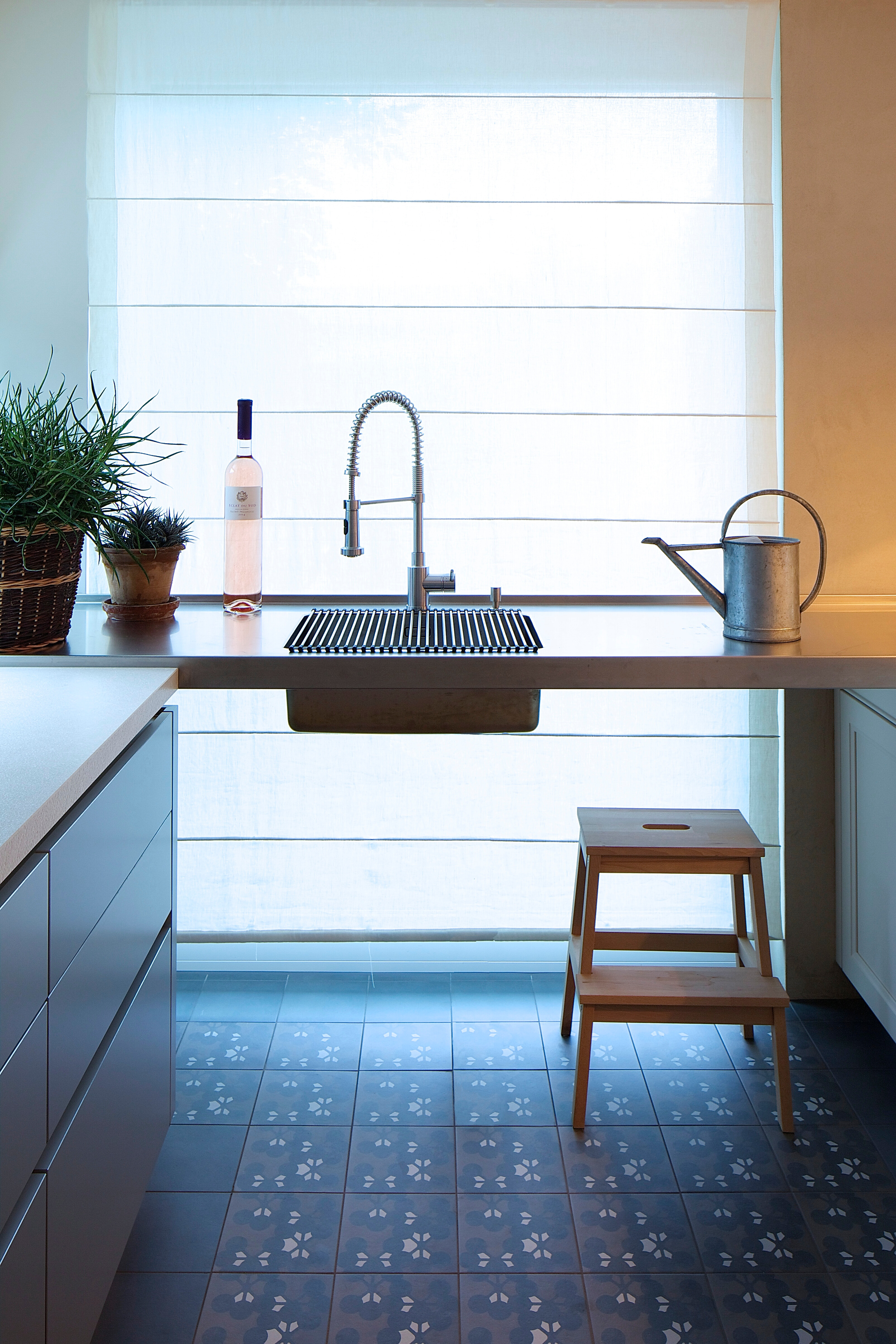 Die frei schwebende Edelstahlarbeitsplatte mit Spüle verbindet die Küchenelemente.