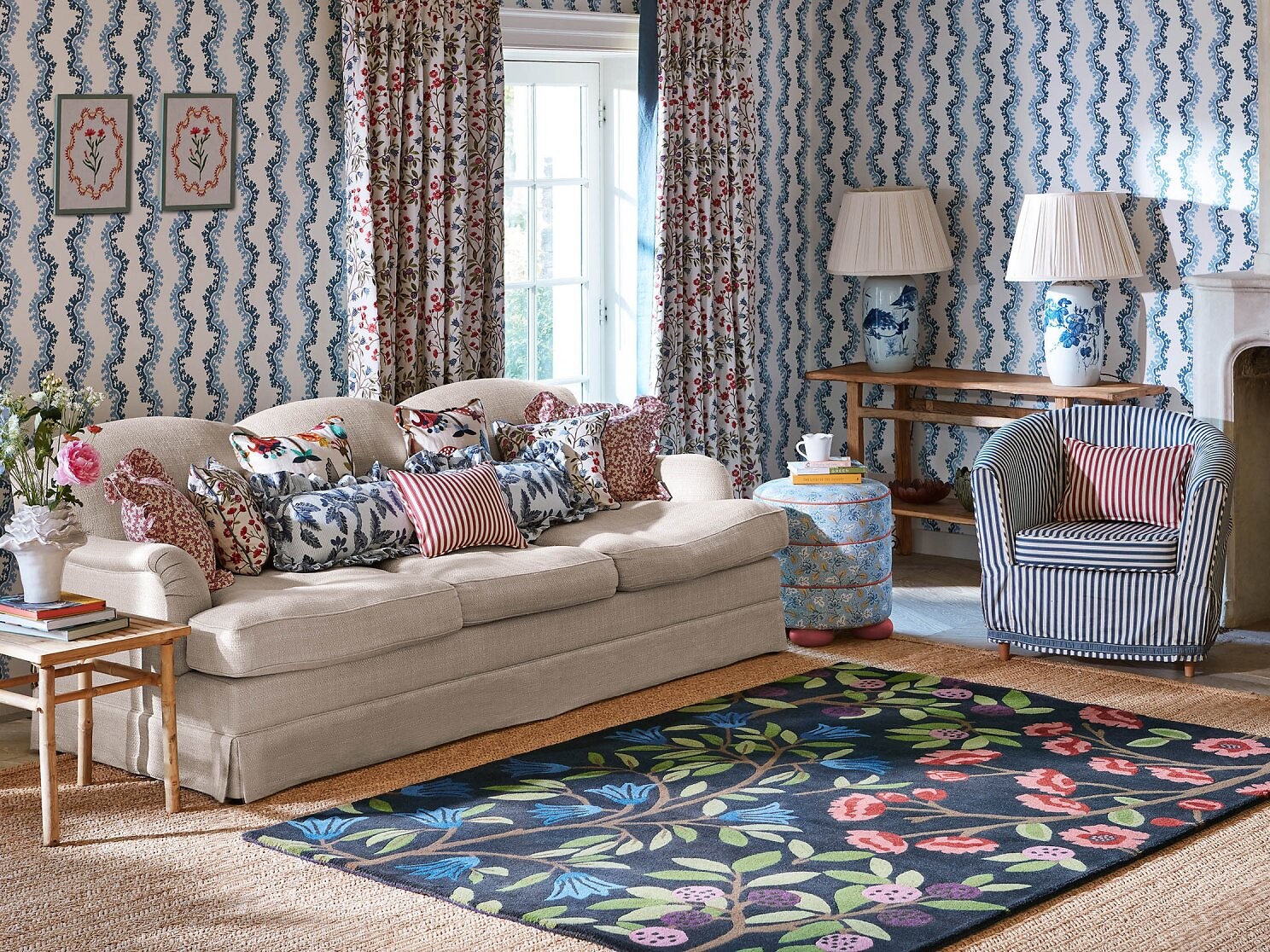 Raum mit gemustertem Teppich und floralen Stoffen an Vorhängen und Kissen  