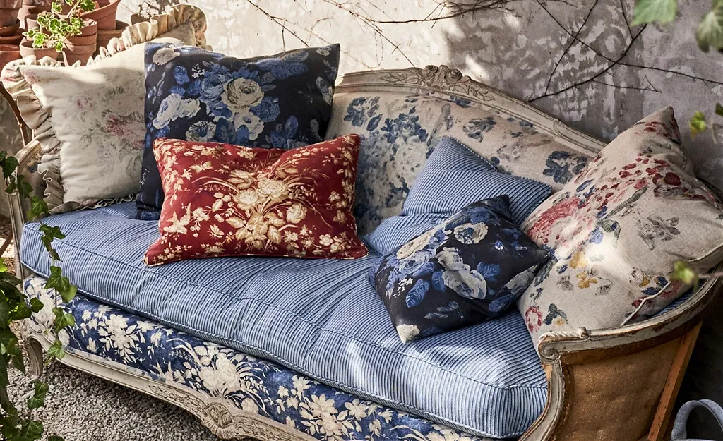 Sofa mit floralen und gestreiften Stoffen, dekoriert mit Kissen in verschiedenen Farben