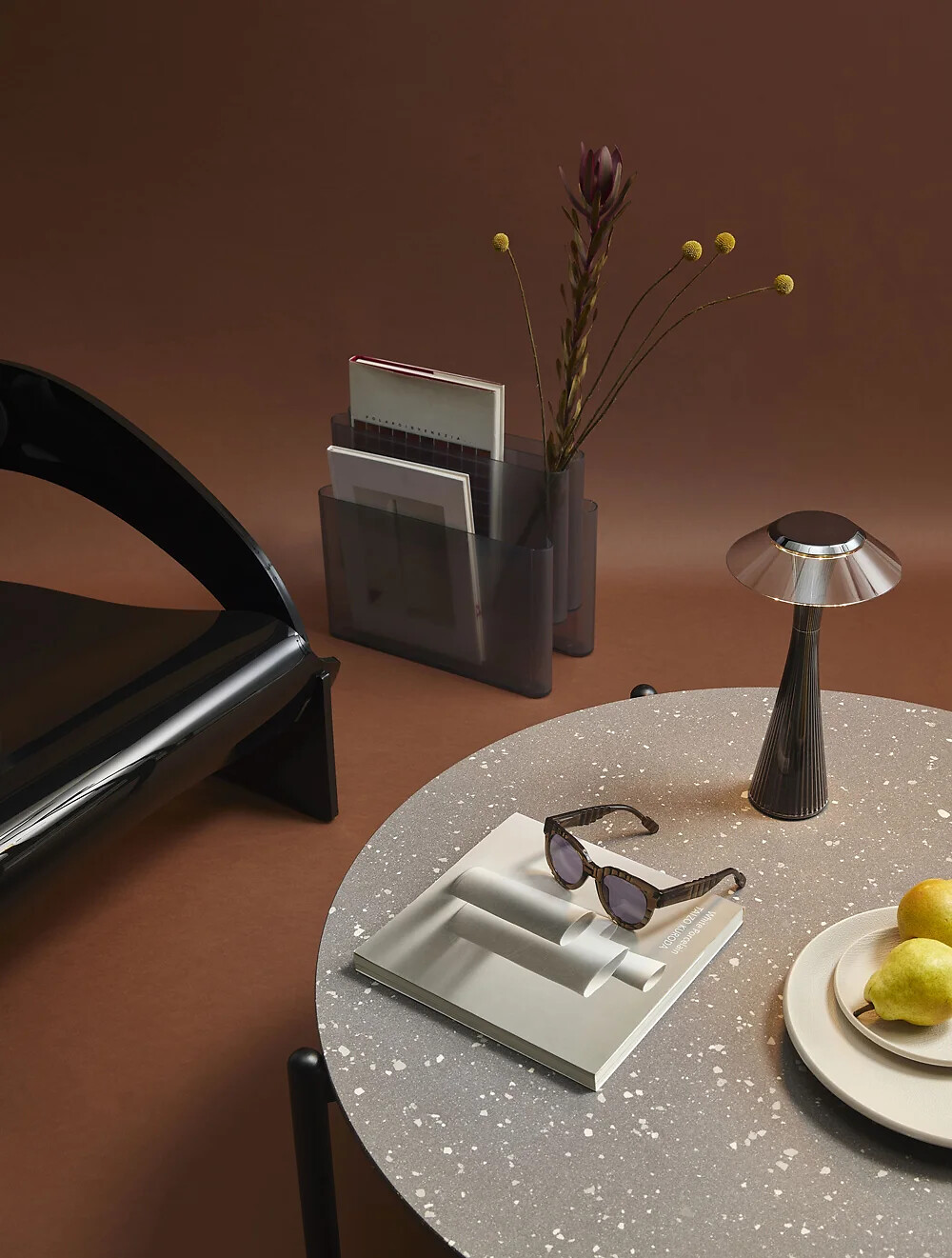 Runder Tisch mit Sonnenbrille, Vase, Lampe und Zeitschriftenständer auf Braunton