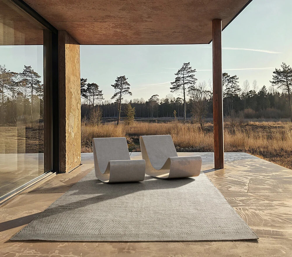 Dezenter Outdoorteppich in Naturkulisse mit zwei Loungestühlen